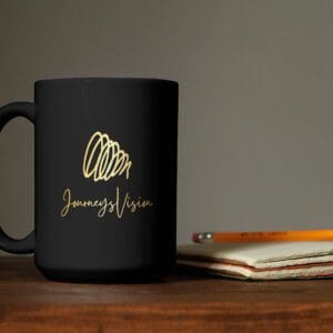 A black coffee mug sitting on top of a wooden table.